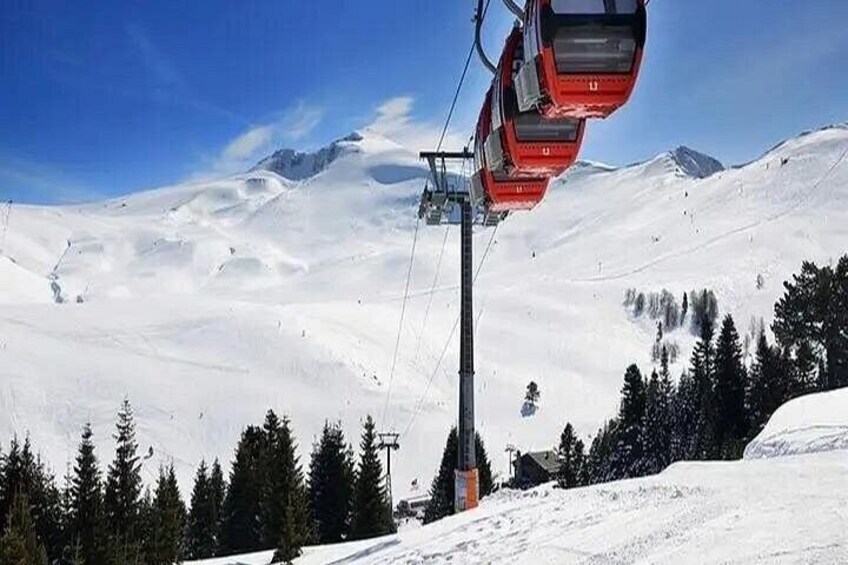 A snowy mountain landscape with a ski lift and trees. 4