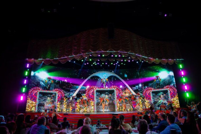 A stage with performers, colorful lights, and a decorated backdrop. 3
