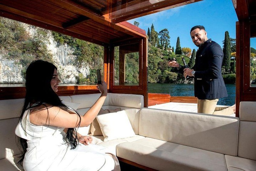 A woman taking a selfie on a boat with a man standing nearby. 1