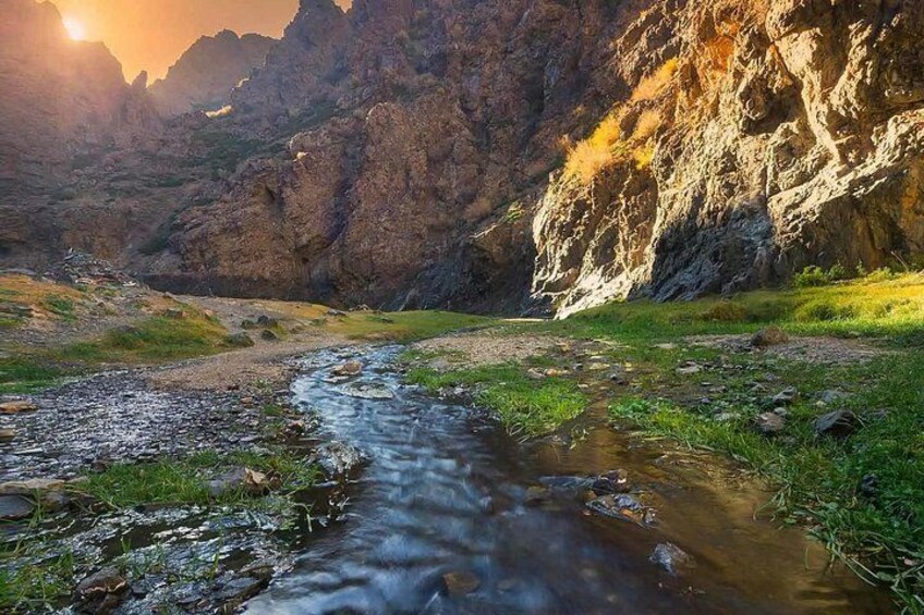 A river flowing through a rocky canyon with sunlight casting shadows on the landscape. 2