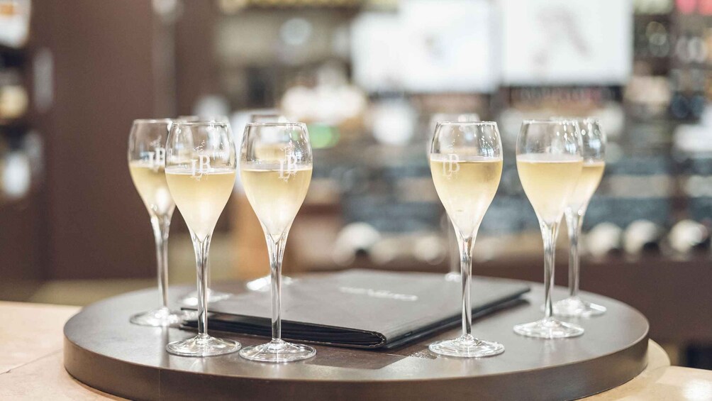 Four champagne glasses on a round table with a blurred background. 3