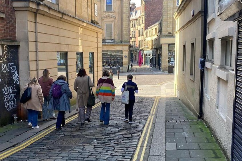 A cobblestone street with pedestrians walking. 3