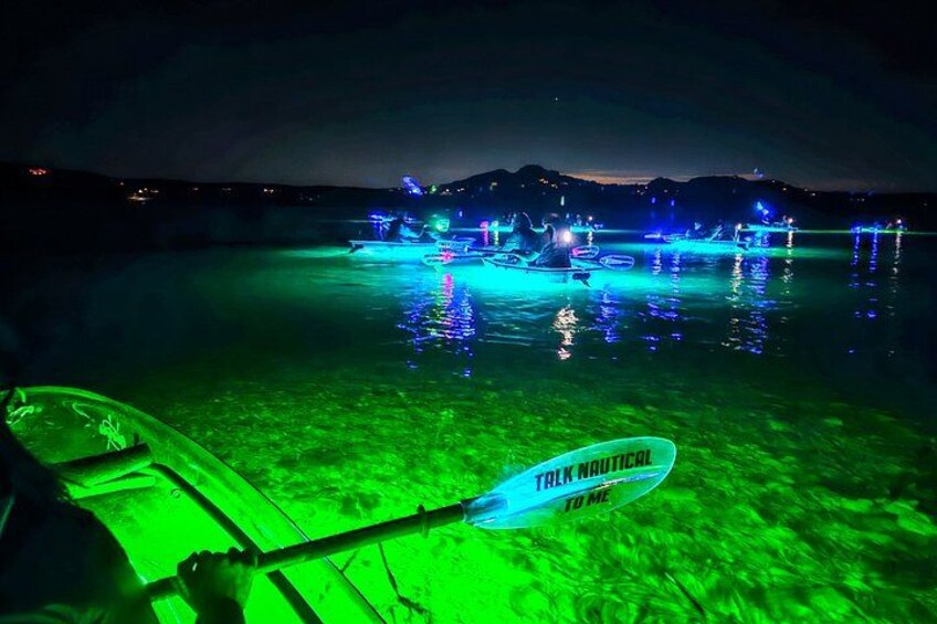 Scena notturna con una barca e strutture illuminate su un'area d'acqua. 5