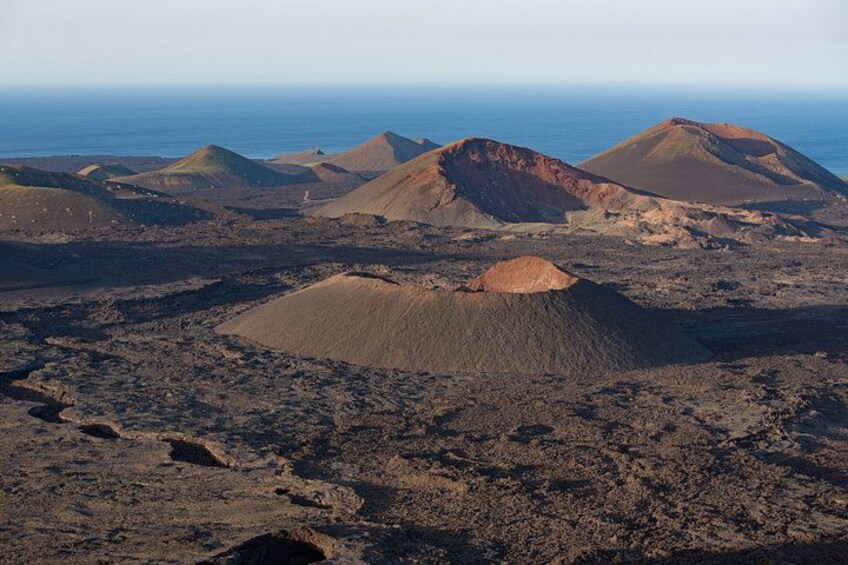 A volcanic landscape with multiple lava formations and a clear sky. 5