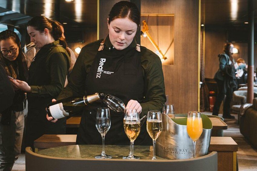 A bartender pouring drinks into glasses on a bar counter. 5