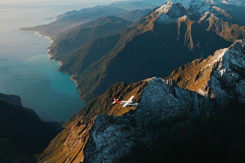 A mountain landscape with a ski lift and a coastal view. 3