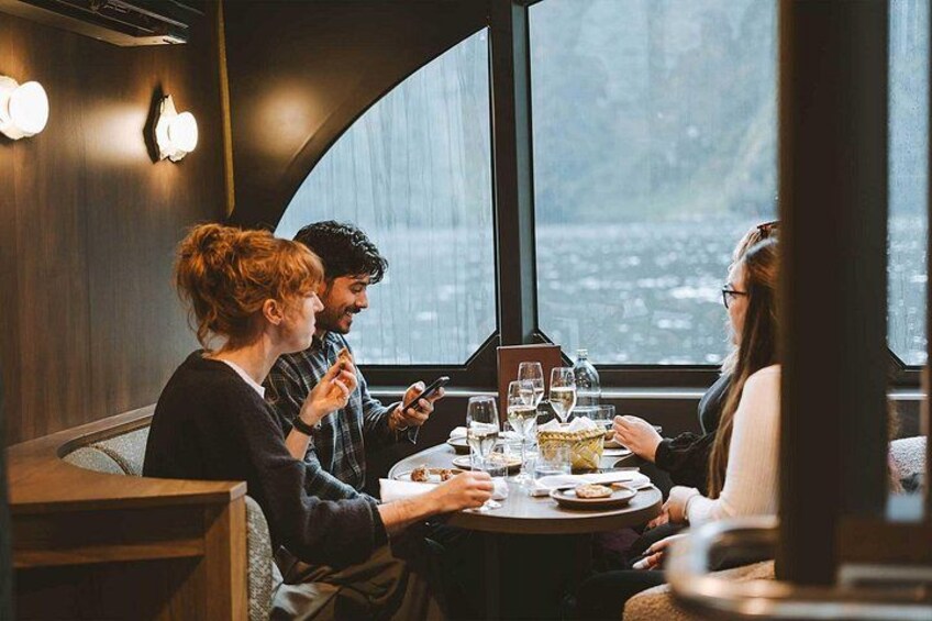 A group of people dining at a table with a view of a body of water. 4