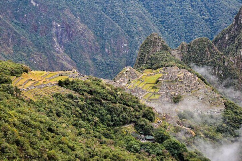 Machu Picchu ruins surrounded by lush green mountains. 1