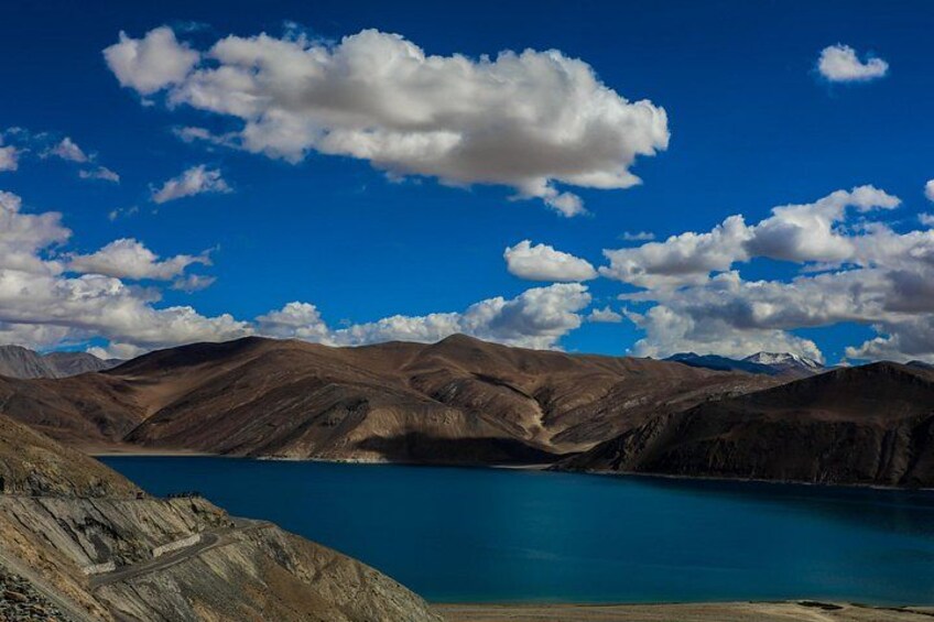 A mountainous landscape with a clear blue lake surrounded by rugged terrain. 1