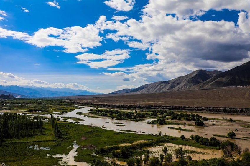 A river winding through a valley with mountains in the background. 3