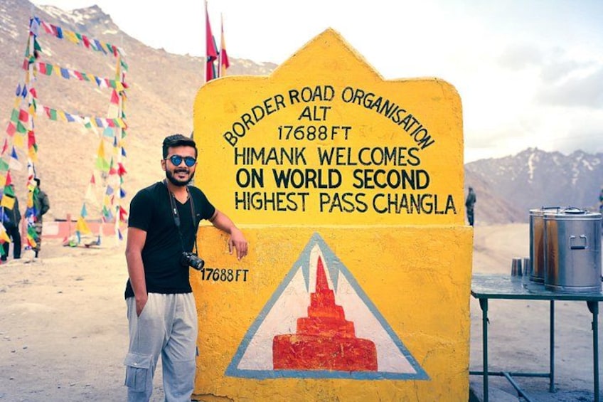 A man standing next to a sign that reads 'Border Road Organisation 17688 FT Himank Welcomes on World Second Highest Pass Changa.' 5