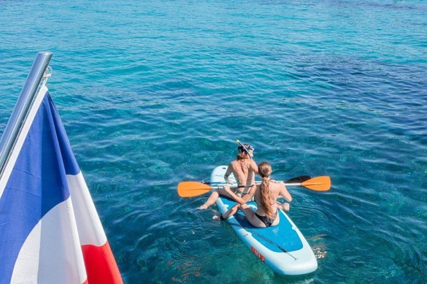Two people kayaking on a clear blue sea. 1