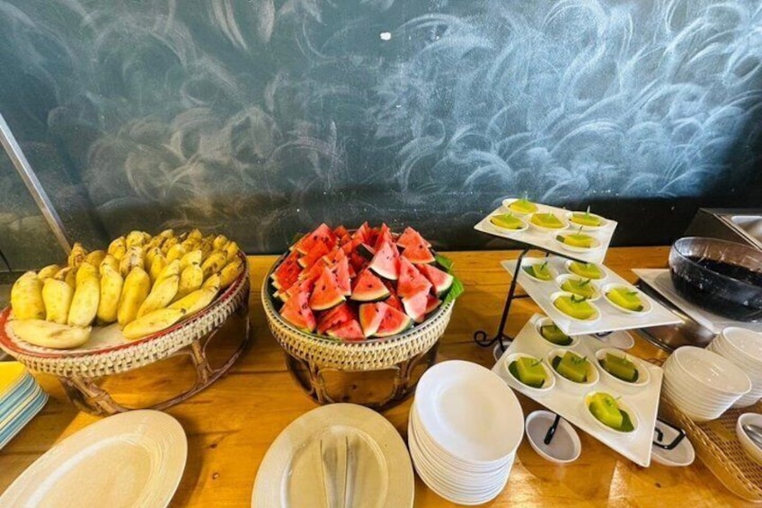 A buffet table with various food items, including fruits and dishes. 4