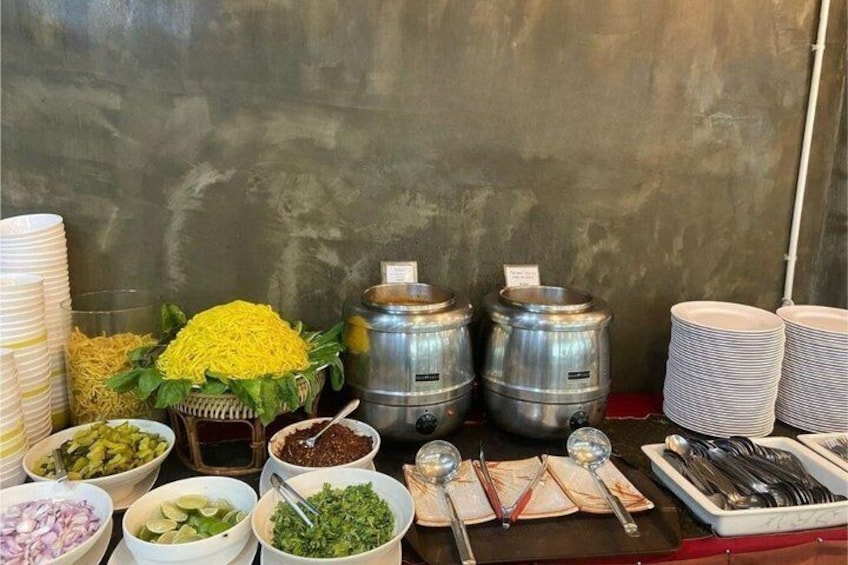 A buffet table with food items, utensils, and condiments. 5