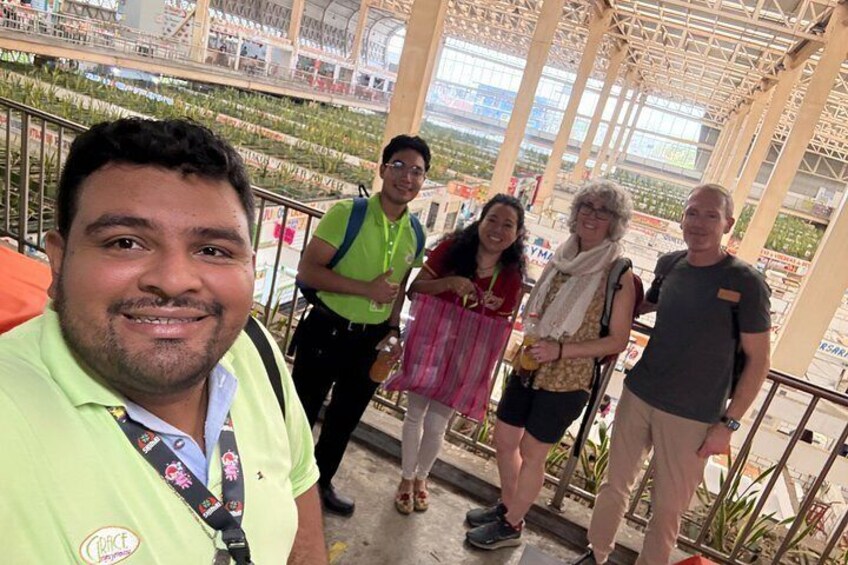 A group of people standing on a balcony with a view of a botanical garden. 2