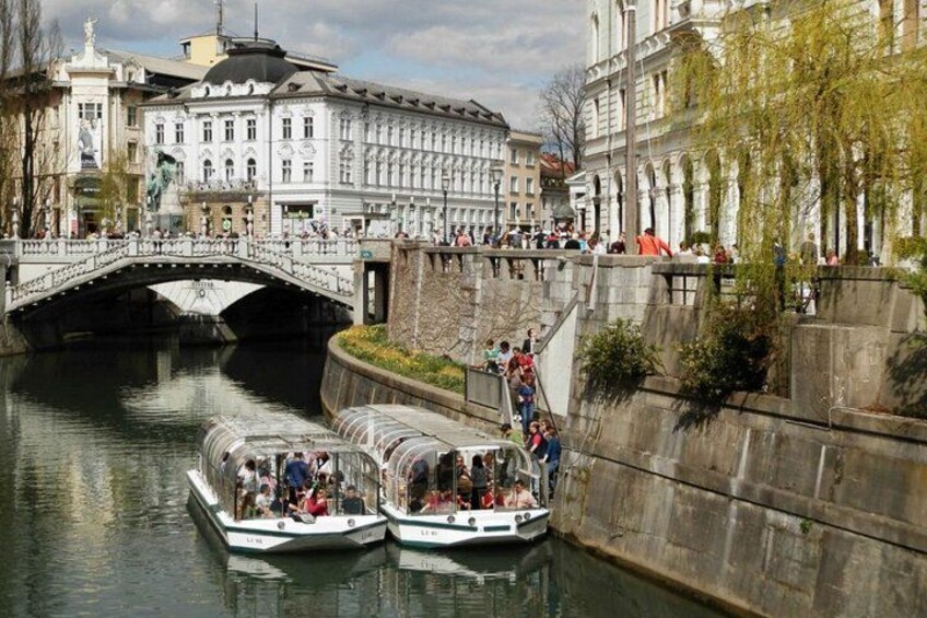 Ein Kanal mit zwei bewohnten Booten, einer Brücke und historischen Gebäuden. 1
