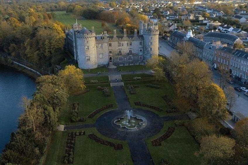 Un castillo rodeado por un foso, una fuente circular y un jardín bien cuidado. 2