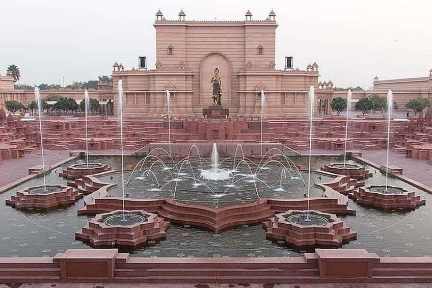 A large, ornate fountain with multiple water jets in a geometric pattern, surrounded by a symmetrical garden layout. 2
