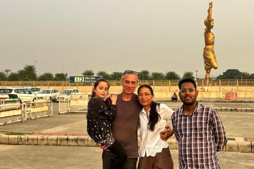Eine Gruppe von Menschen posiert vor einer großen goldenen Statue. 2