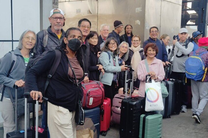 A group of people with luggage at an airport. 2