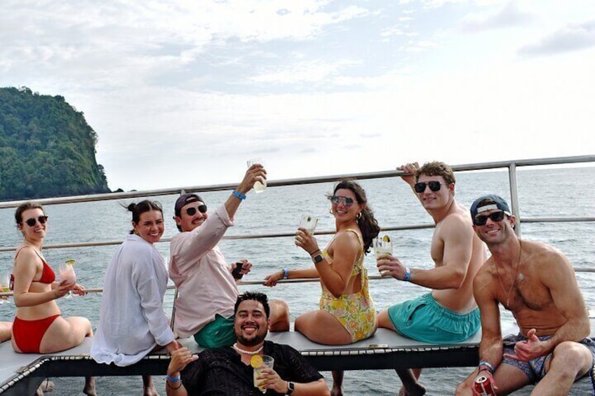 A group of people on a boat with a forested island in the background. 4