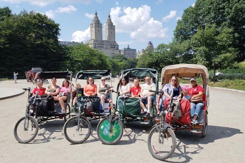 Un grupo de personas en sillas de ruedas y un vehículo accesible para sillas de ruedas en un entorno al aire libre con árboles y un edificio al fondo. 5