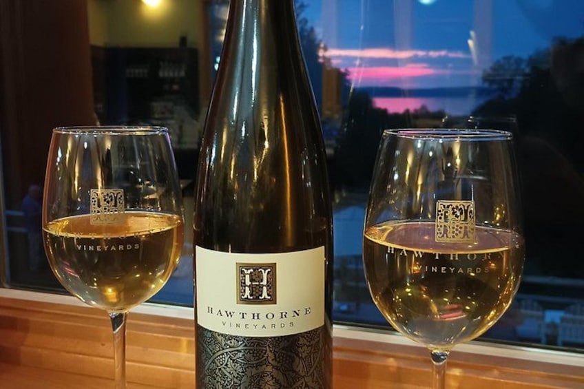 A bottle of Hawthorne Vineyards wine with two glasses of wine on a table. 4