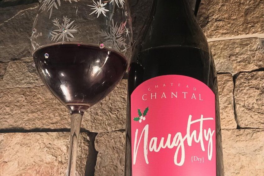 A bottle of Chateau Chantal Naughty [Dry] wine next to a wine glass. 3