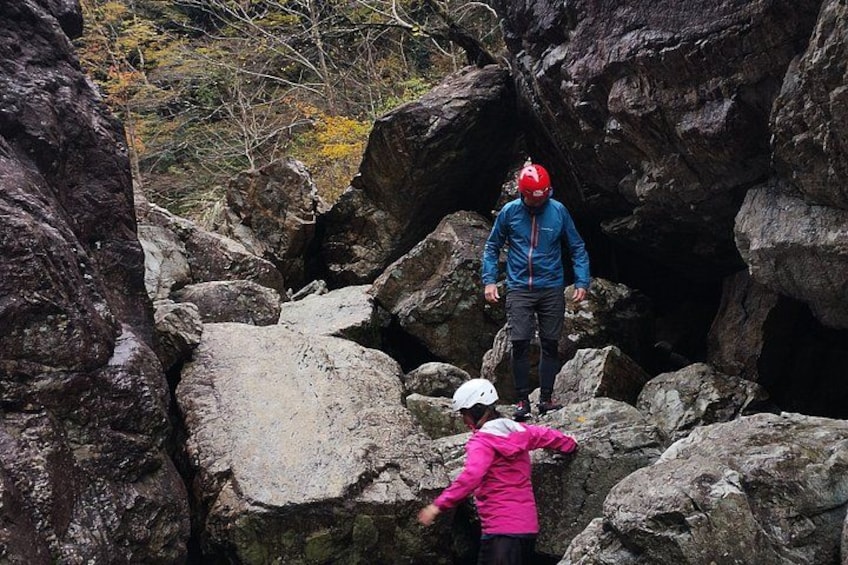 Two people navigating rocky terrain, one in a blue jacket and the other in a pink jacket. 3