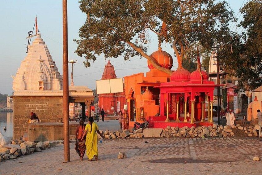 A riverside temple complex with a prominent white temple and a red structure. 1