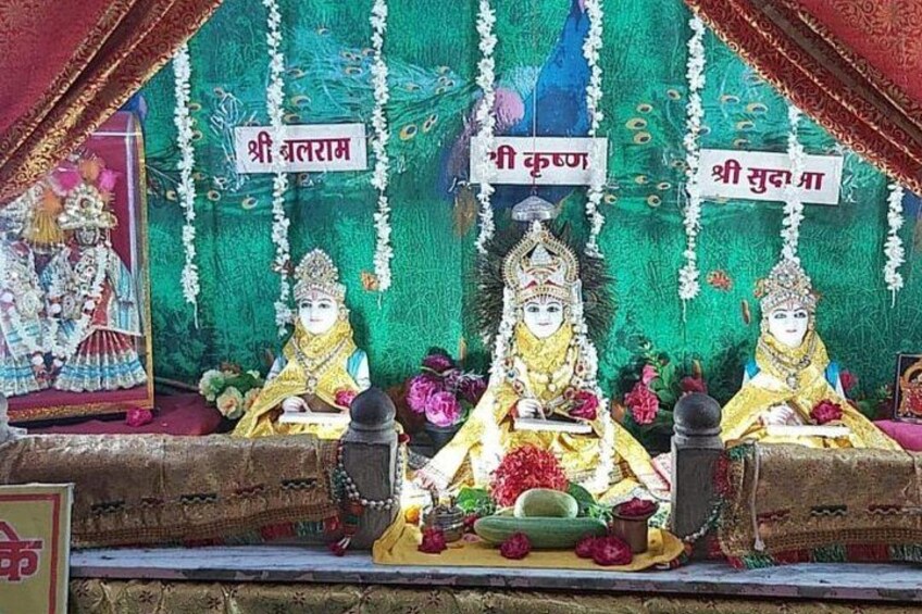 A shrine with three statues, each labeled with a name in a local script. 3