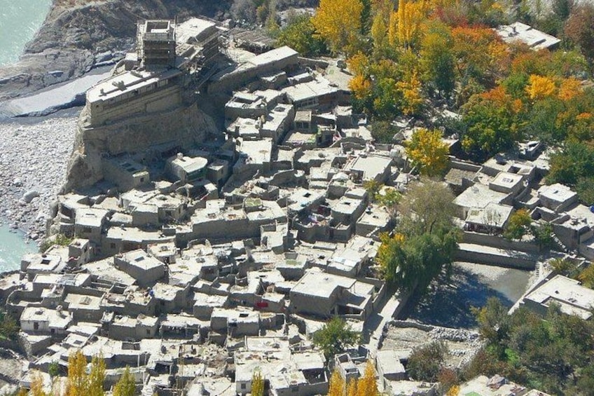 Un pueblo costero con arquitectura tradicional, un litoral rocoso y árboles de colores otoñales. 3
