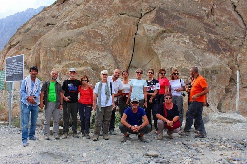 Un grupo de personas frente a una montaña rocosa con un letrero. 5