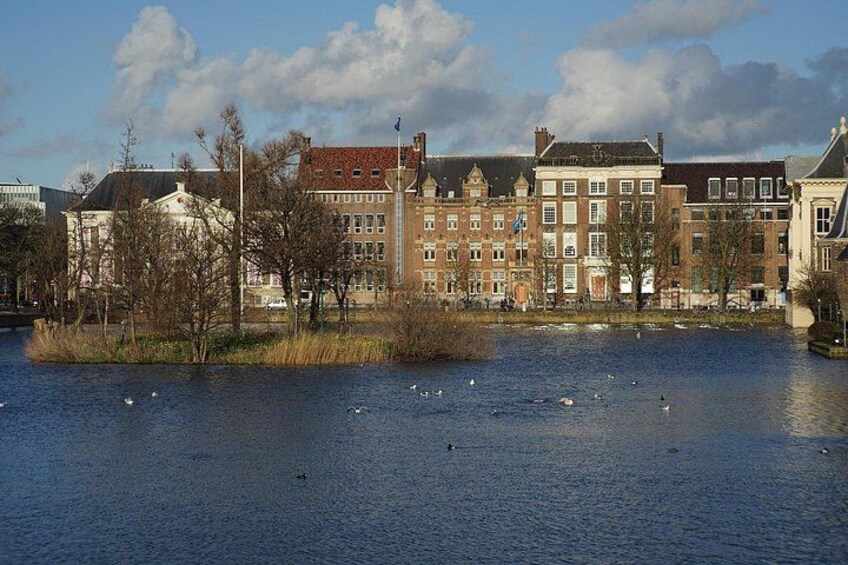 En flod med svanar, en bro och historiska byggnader. 2