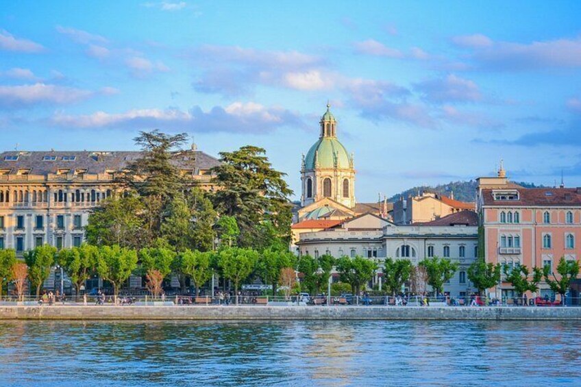 Paesaggio urbano con vista sul fiume, una chiesa imponente, un filare di alberi e un fiume tranquillo. 1