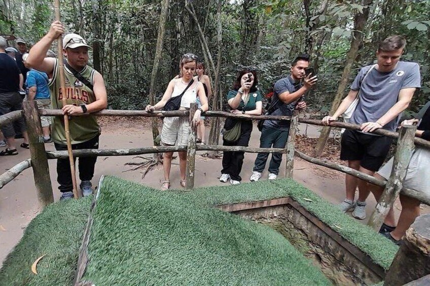 Un grupo de personas de pie detrás de una valla de madera en un área boscosa. 2