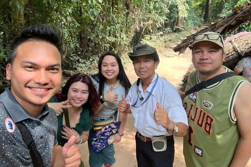 Un grupo de personas en un área boscosa con abundante vegetación y un sendero de tierra. 1