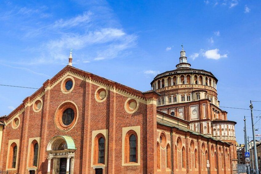 Una iglesia de ladrillo rojo con una cúpula y ventanas de arco. 2