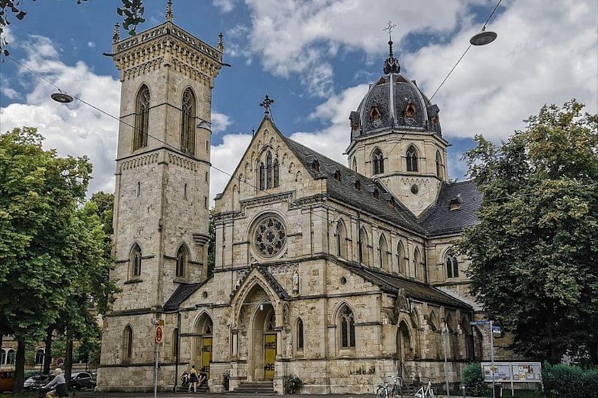 Una iglesia histórica con una torre destacada y una cúpula grande. 1