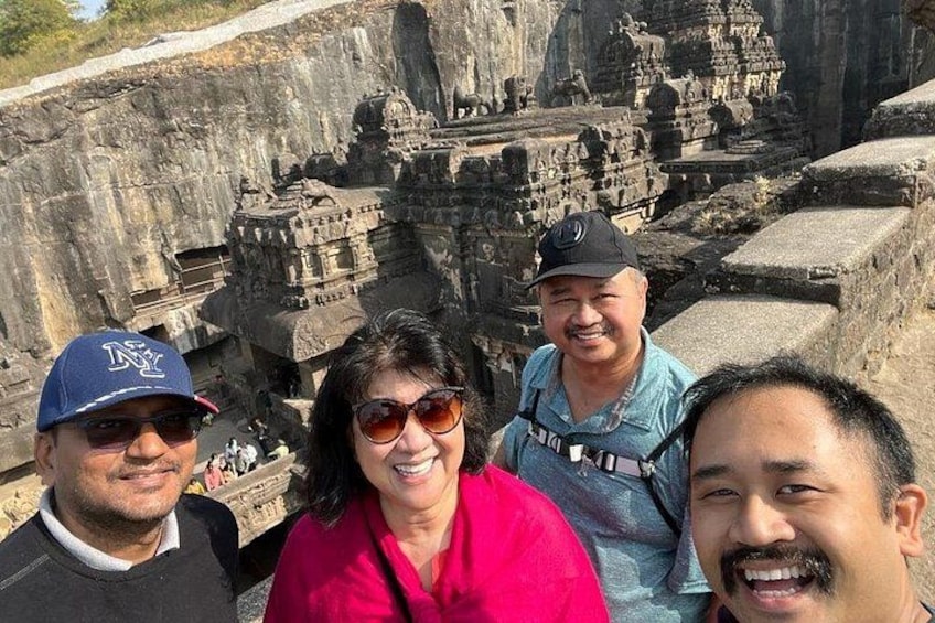 A group of people standing in front of ancient stone structures. 2