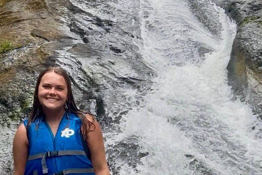 Una persona de pie frente a una cascada. 3