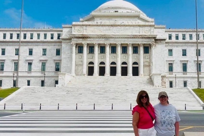 A large white building with columns and a dome, a wide staircase leading up to it, and a clear blue sky. 2
