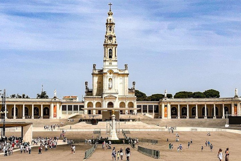 Une vaste place publique, dominée par une église imposante avec un haut clocher, le tout entouré d’une colonnade. 3