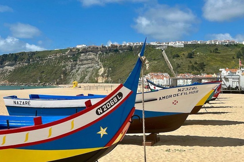 Colorful boats on a beach with a town in the background. 3