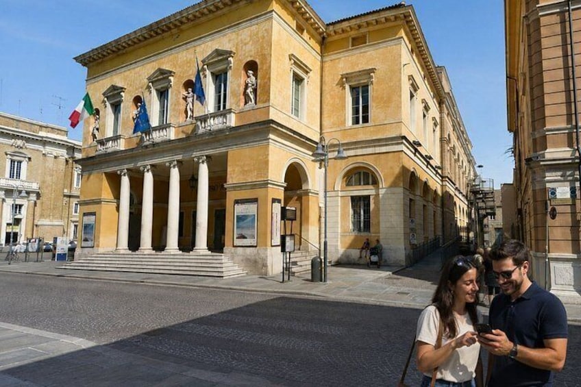 A historic building with columns, flags, and a clear sky. 5