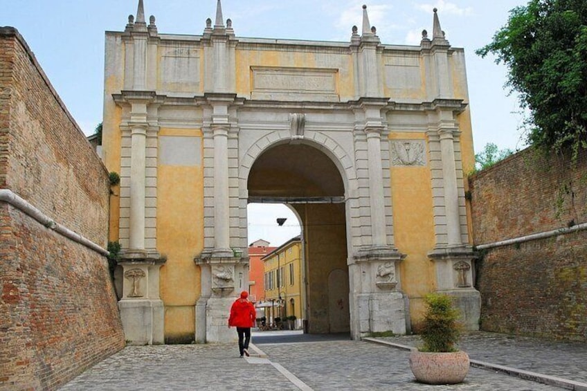 A historical archway with a person walking through it. 3
