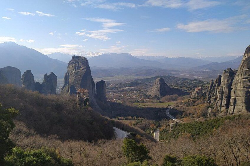 A mountainous landscape with rock formations, a winding road, and a river. 1
