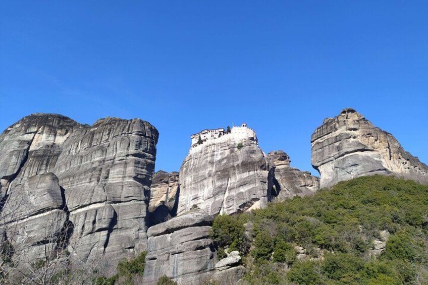 Una gran formación rocosa con un pequeño edificio en la cima. 5