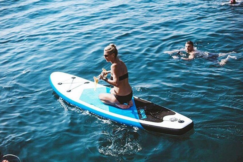 Iemand zit op een paddleboard in het water. 2