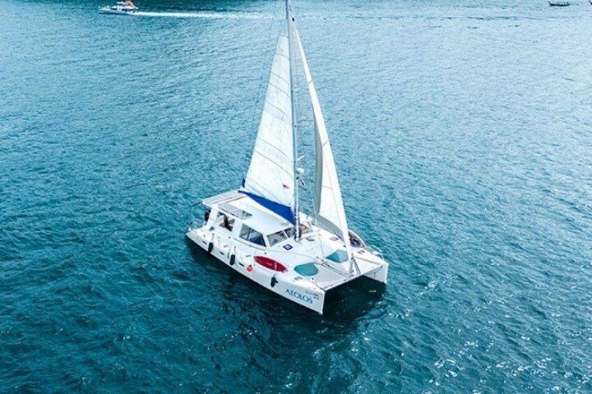Un velero con casco blanco y detalles azules sobre el agua. 1